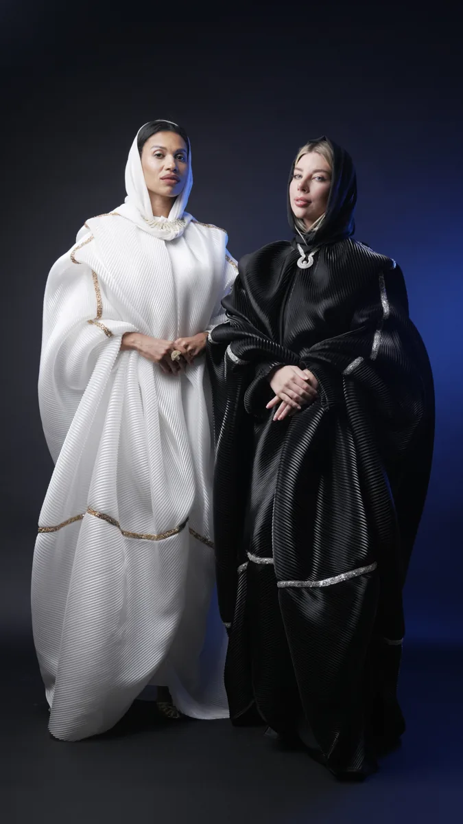 Two models wearing contrasting white and black outfits